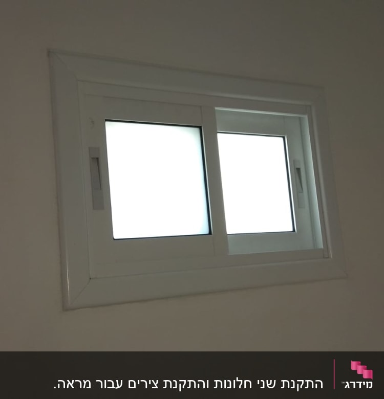 חלון אלומיניום עם מסגרת לבנה על קיר